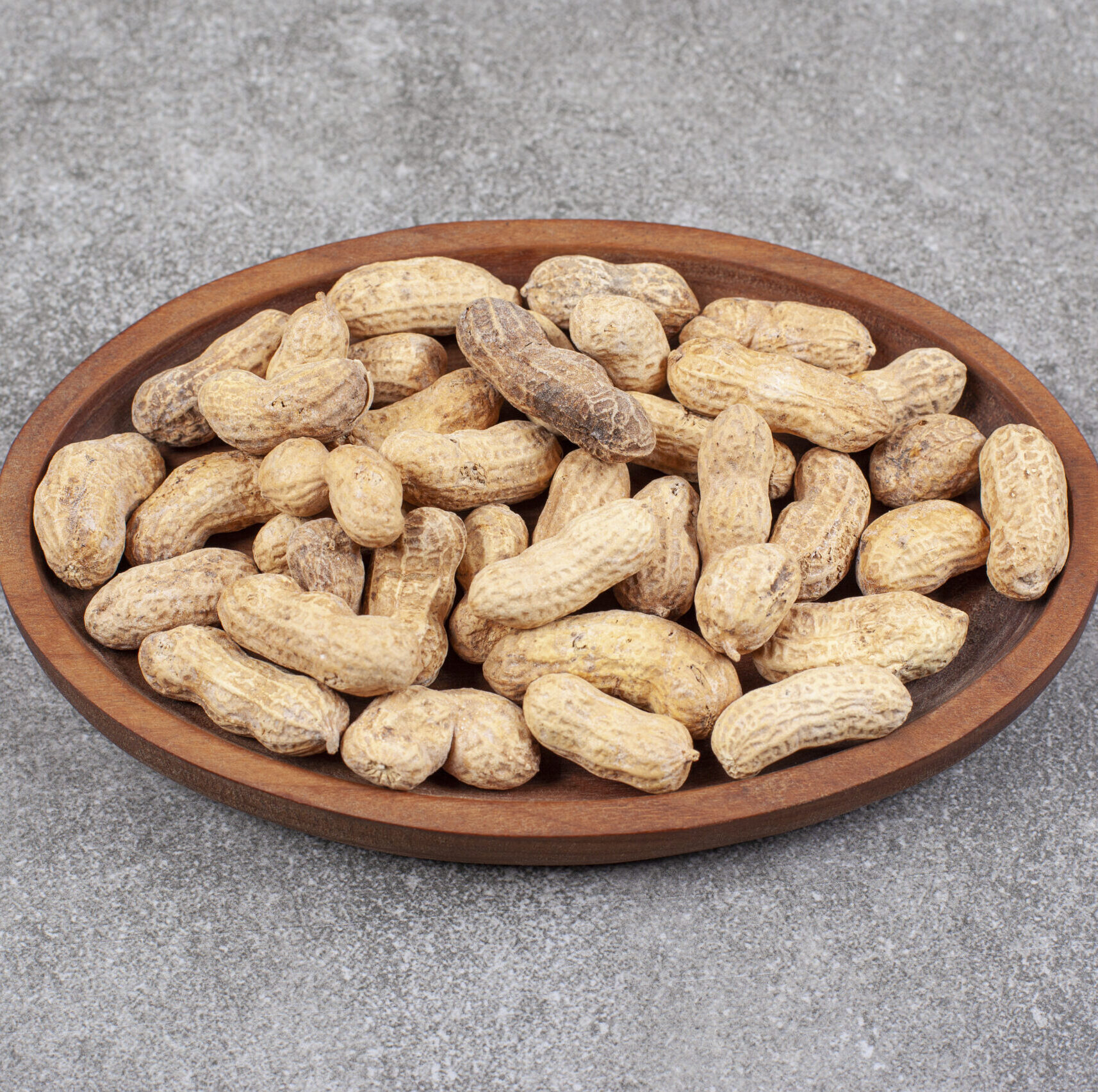 A wooden board full of healthy peanuts in shell. High quality photo